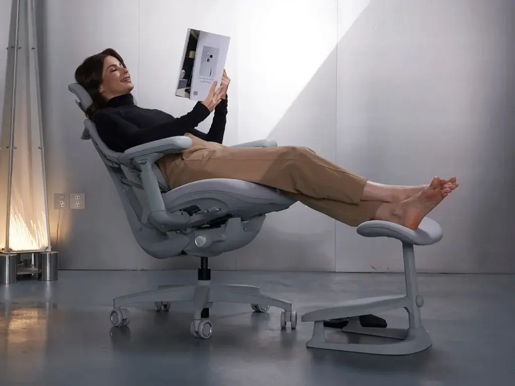 Libernova Dynamic ergonomic mesh chair shown at an angle, highlighting its full back support and footrest in relaxed position